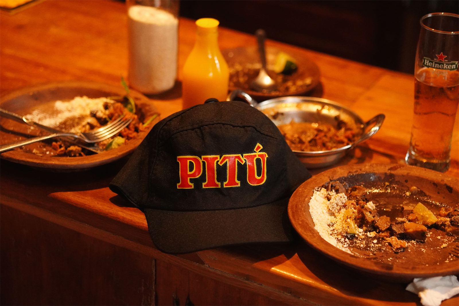 Mesa do bar do Gracinha com boné da cachaça Pitú e chope gelado