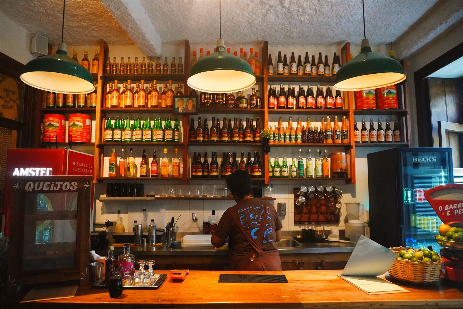 Balcão da cachaçaria do Gracinha, com prateleiras de cachaça e cervejas artesanais