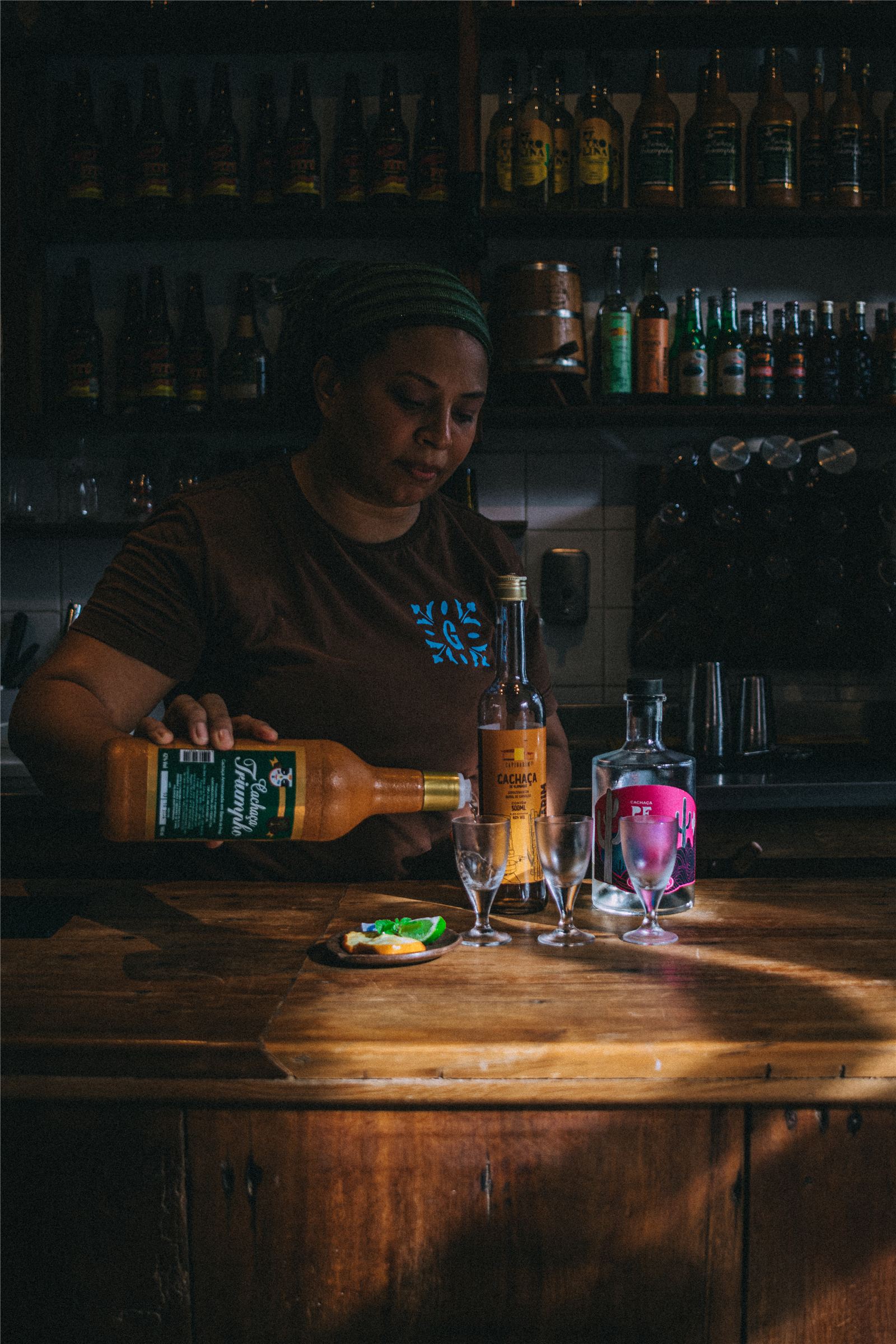 Equipe do Gracinha servindo cachaça artesanal no balcão da cachaçaria