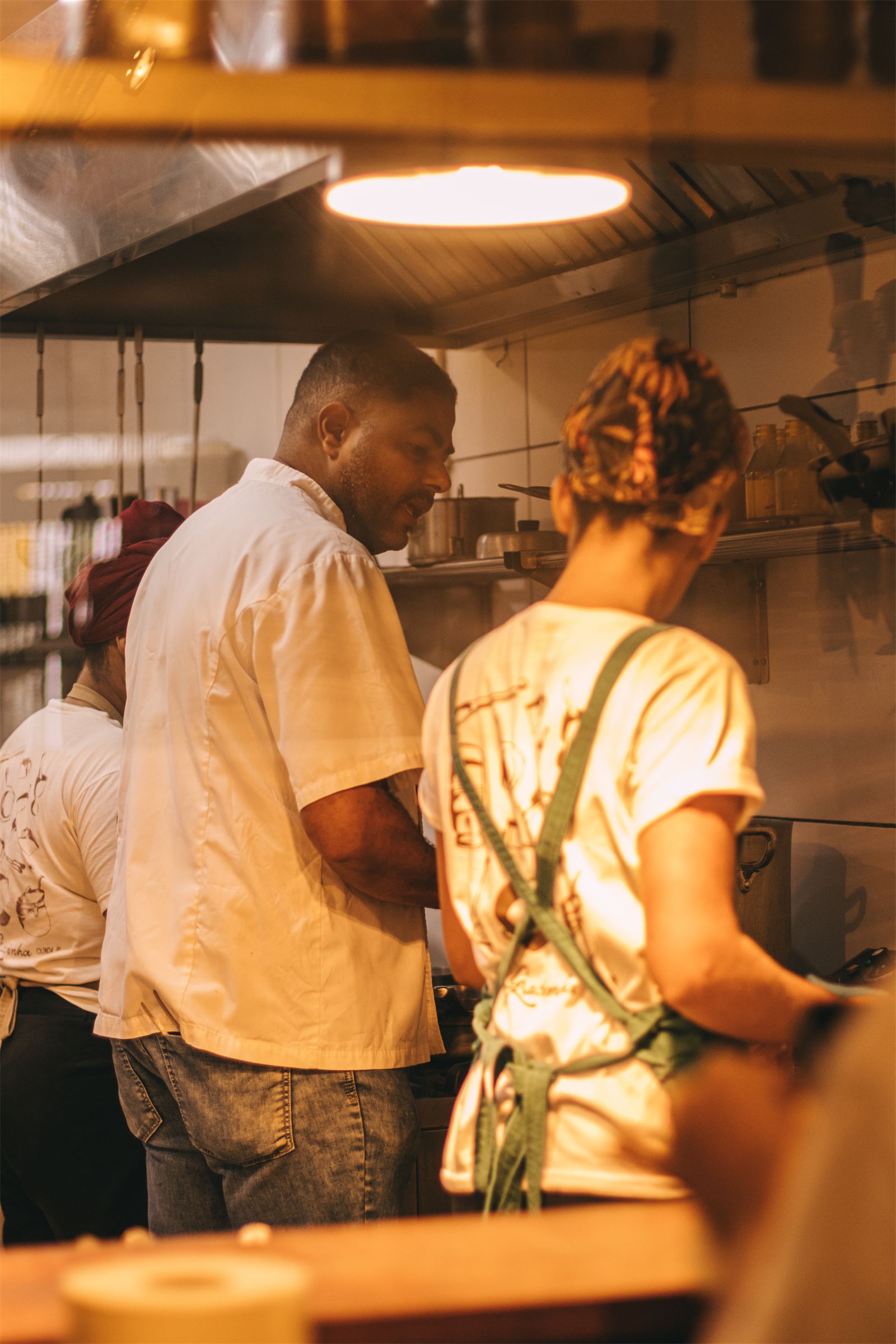 Equipe da cozinha do Gracinha preparando pratos no fogão, em Olinda