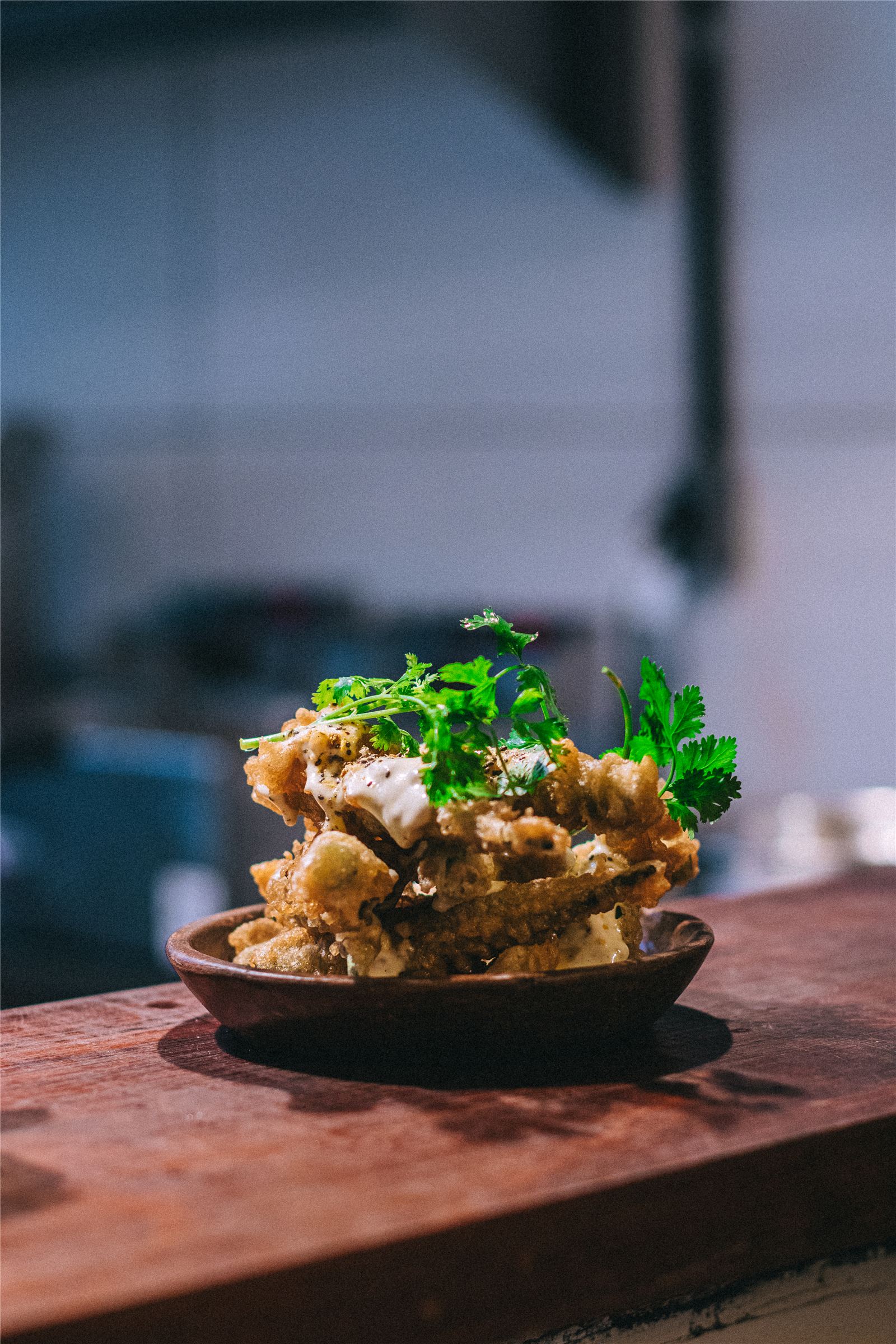 Isca frita à moda do Gracinha, servida em tábua com molho e coentro